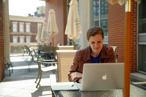 student studying at an outdoor table on campus